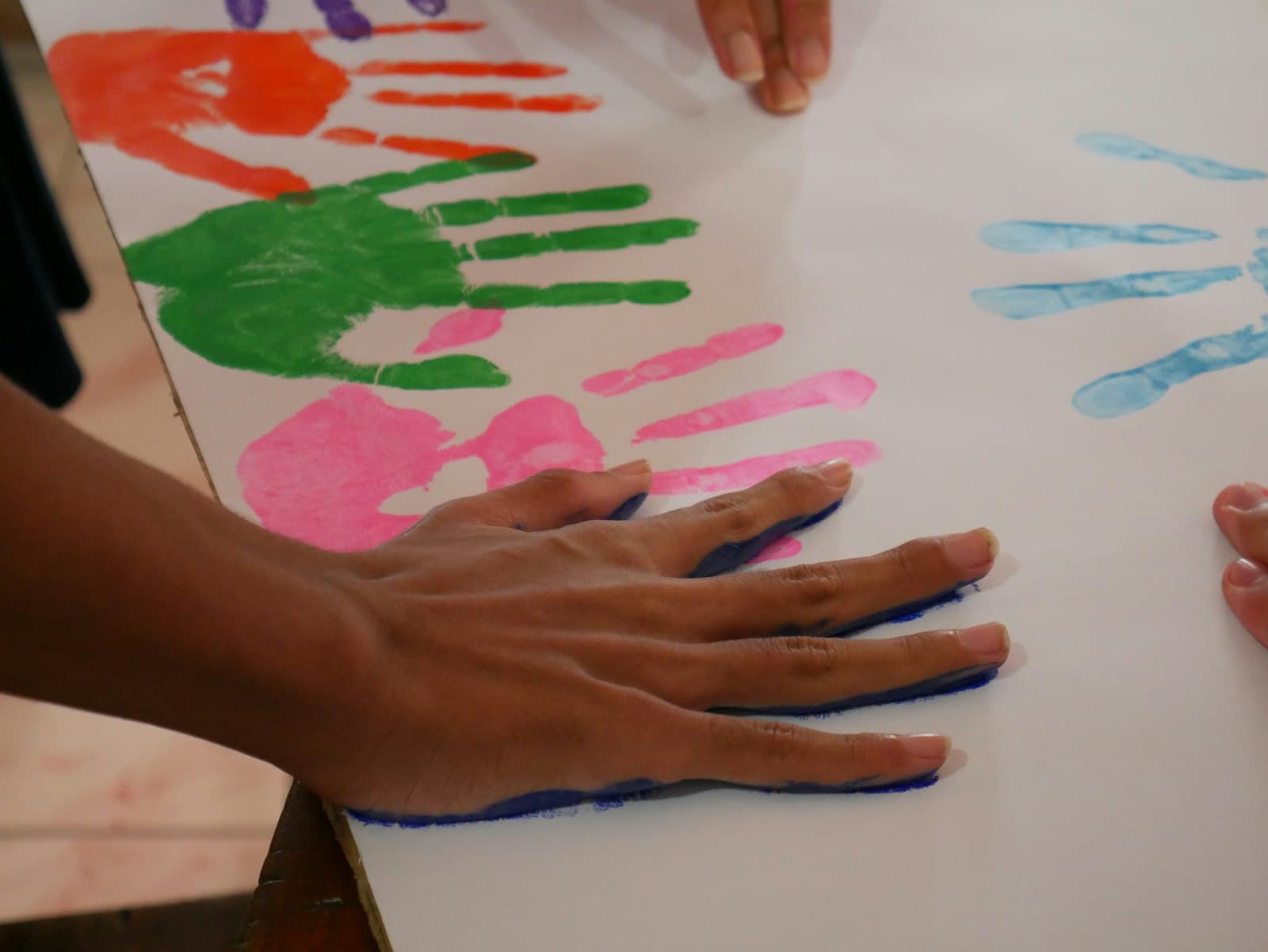 Colorful toddler handprints stamped on white paper